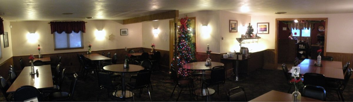 The dining room at Wouters' Front, set with tables, chairs and table numbers, decorated for Christmas